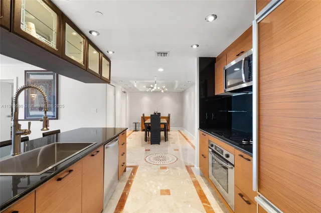 a kitchen with stainless steel appliances granite countertop a sink and a granite counter tops with a large window