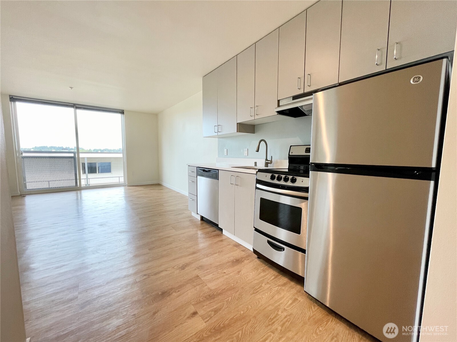 2249 Northeast 46th Street Seattle, WA 98105 - Photo 17 of 20 a kitchen with granite countertop a refrigerator and a stove top oven