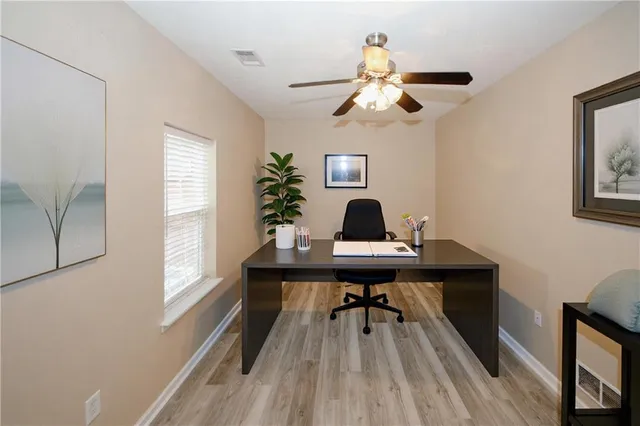 a view of a workspace with furniture and a window