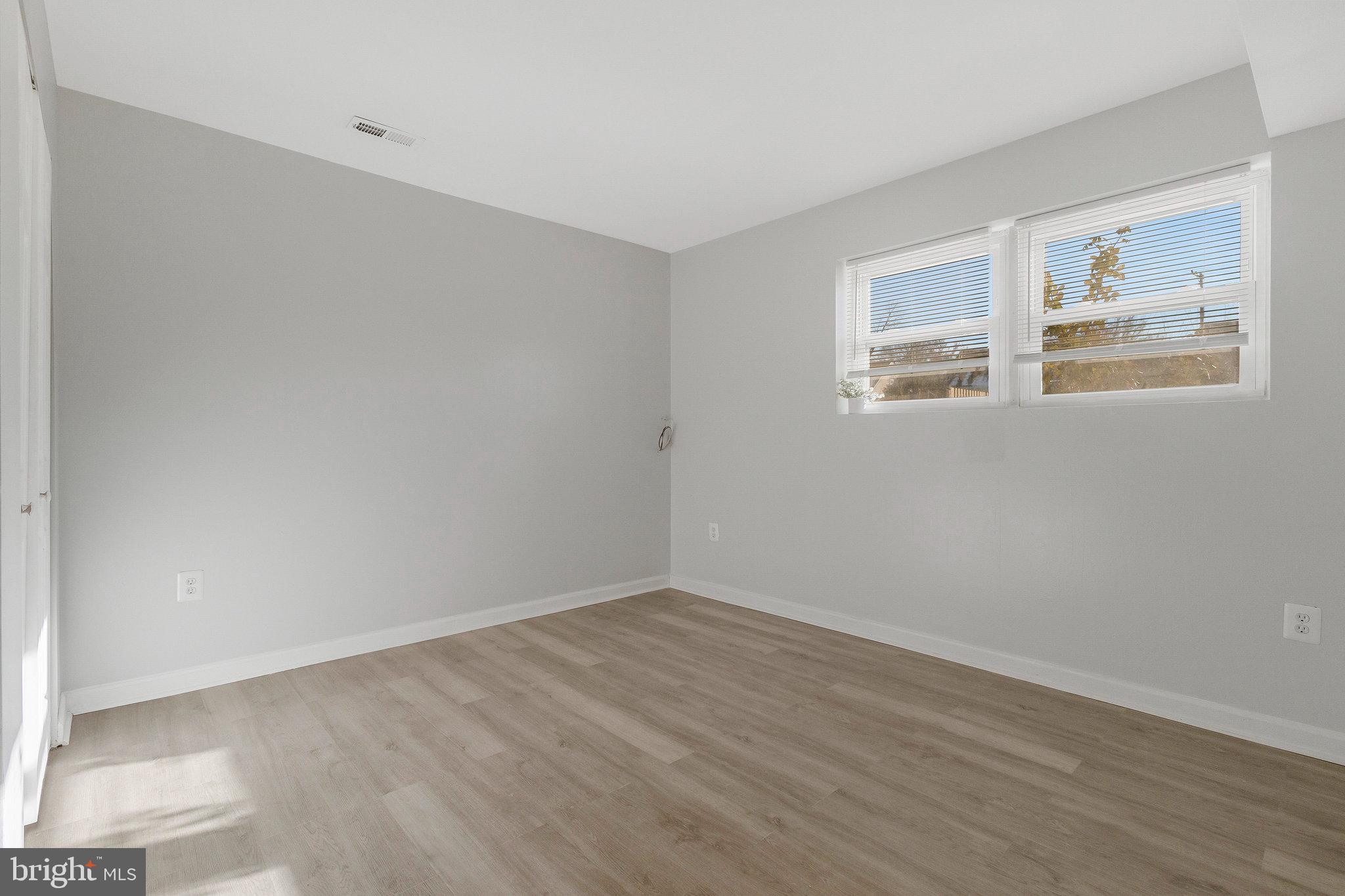 5004 Roanoke Place College Park, MD 20740 - Photo 19 of 27 a view of empty room with wooden floor and fan