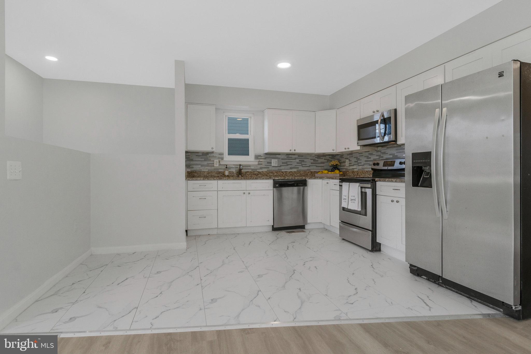 5004 Roanoke Place College Park, MD 20740 - Photo 2 of 27 a kitchen with stainless steel appliances granite countertop a stove a sink and a refrigerator