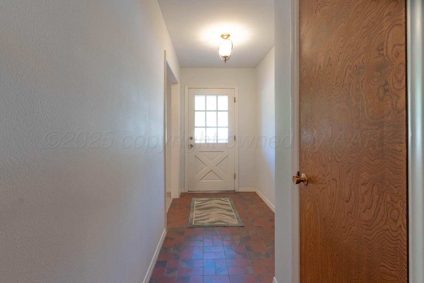 6207 Elmhurst Road Amarillo, TX 79106 - Photo 10 of 21 an empty room with wooden floor mirror and windows
