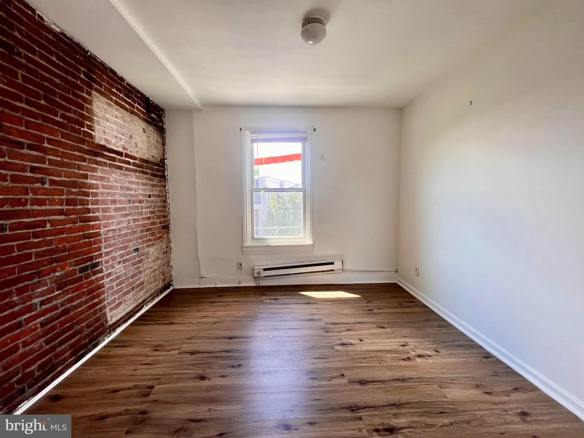 1249 Shackamaxon Street, Unit 3F Philadelphia, PA 19125 - Photo 2 of 12 a view of an empty room with wooden floor and a window