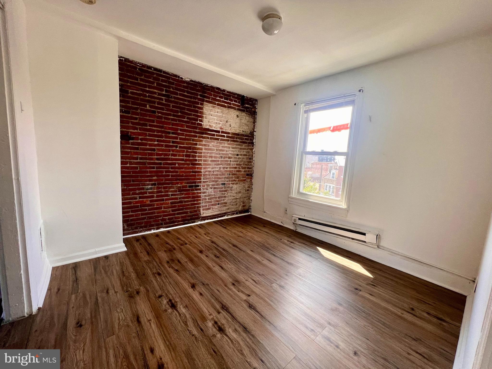 1249 Shackamaxon Street, Unit 3F Philadelphia, PA 19125 - Photo 3 of 12 an empty room with wooden floor and windows