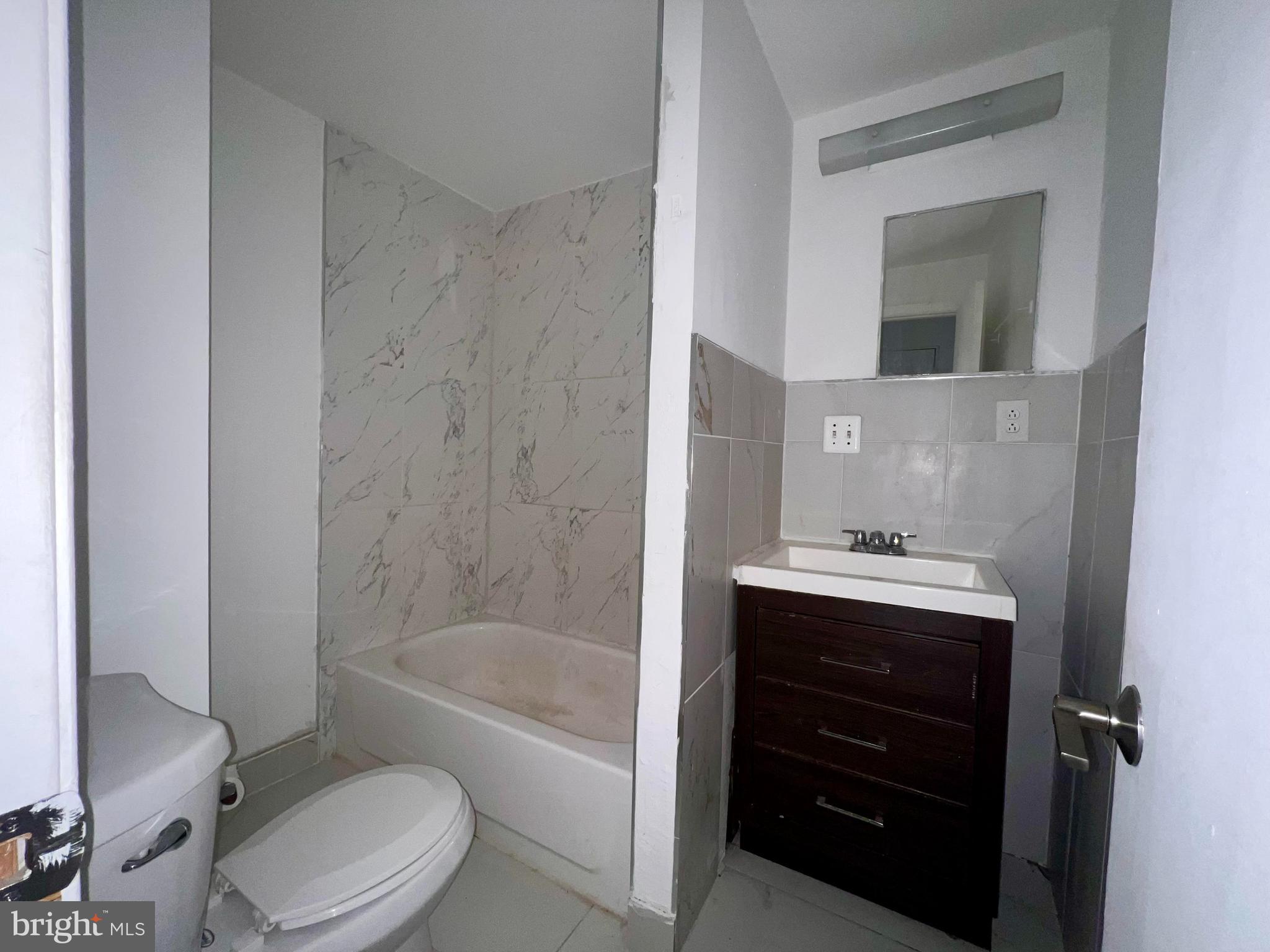 1249 Shackamaxon Street, Unit 3F Philadelphia, PA 19125 - Photo 7 of 12 a bathroom with a sink a toilet and bathtub