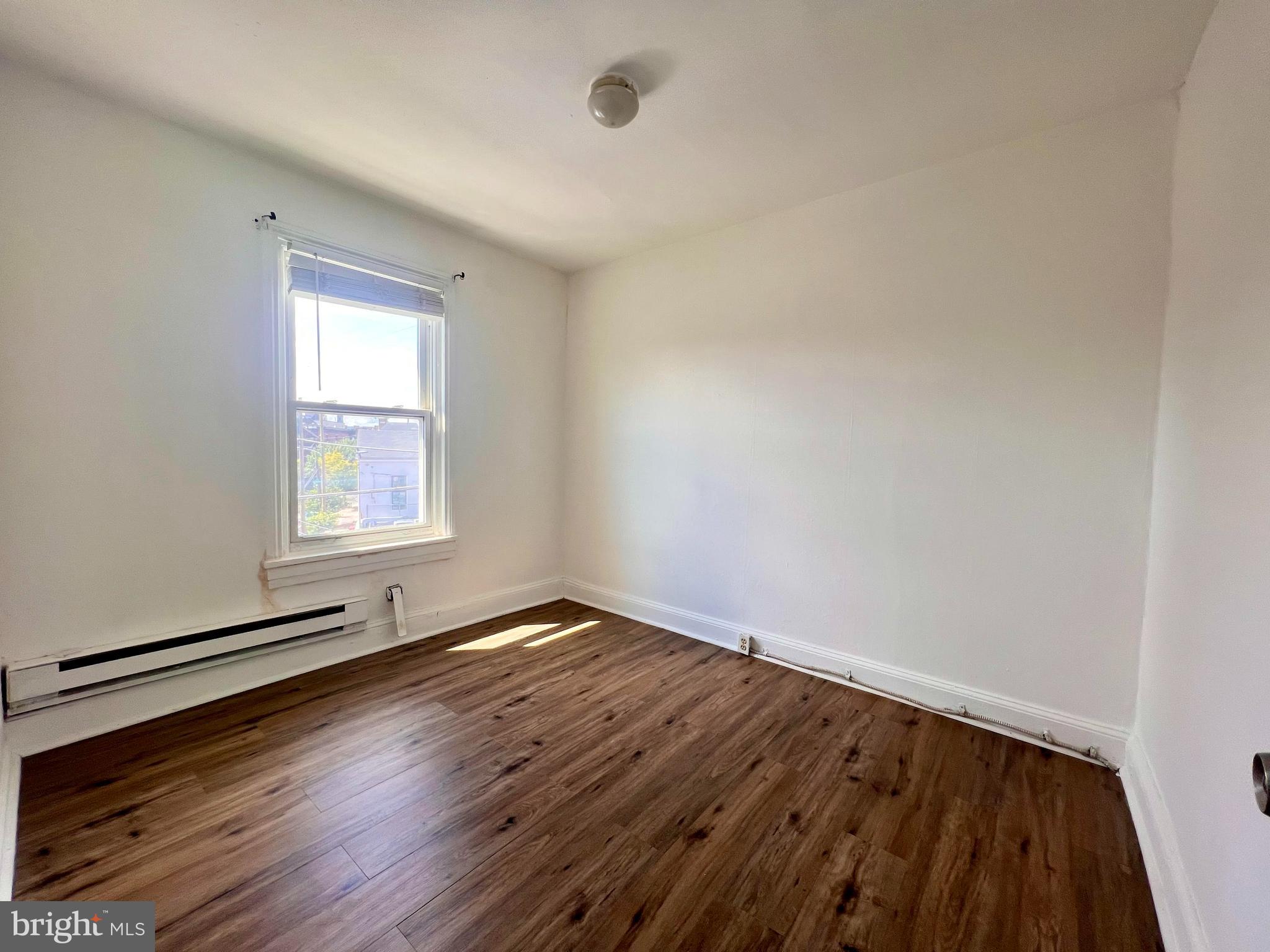 1249 Shackamaxon Street, Unit 3F Philadelphia, PA 19125 - Photo 8 of 12 an empty room with wooden floor and windows