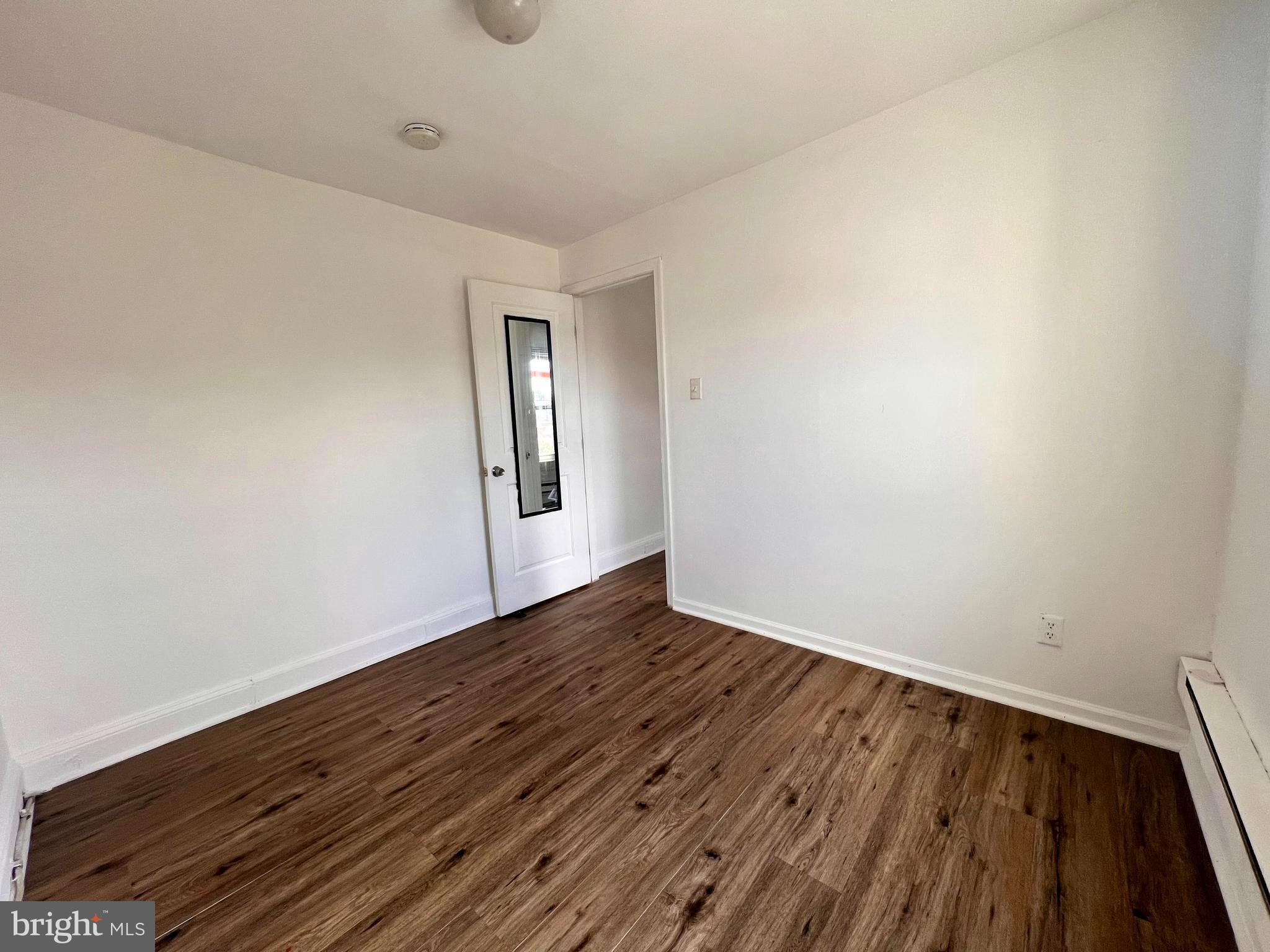 1249 Shackamaxon Street, Unit 3F Philadelphia, PA 19125 - Photo 9 of 12 a view of an empty room with wooden floor and a window