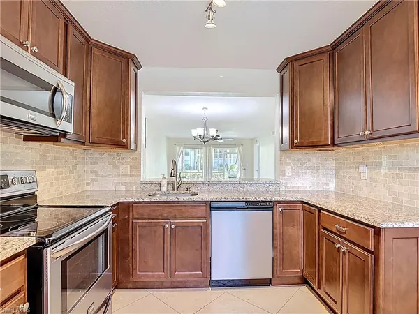 a kitchen with stainless steel appliances granite countertop a sink stove and microwave