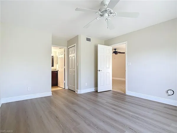a view of an empty room with wooden floor