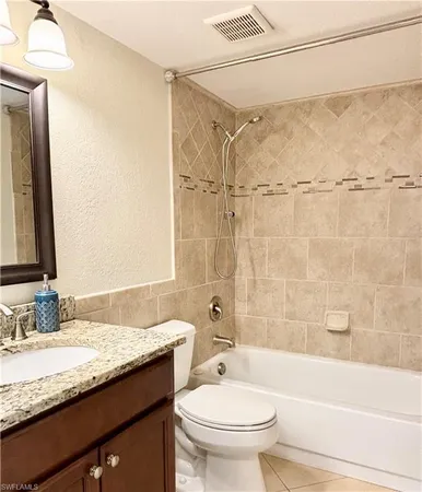 a bathroom with a granite countertop sink a toilet and shower