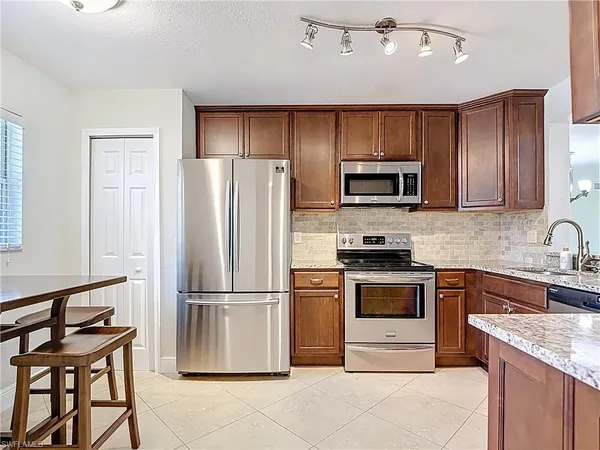 a kitchen with granite countertop a refrigerator stove and microwave