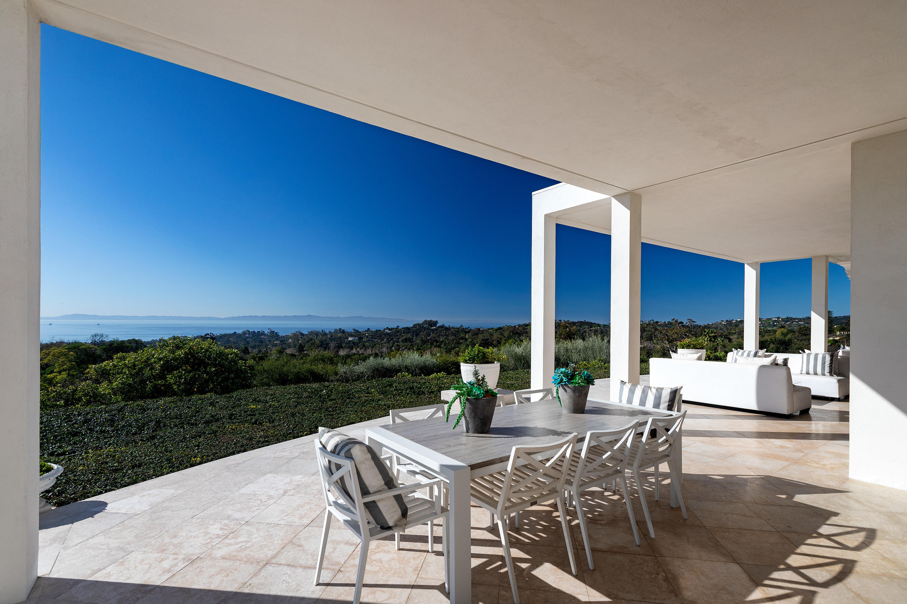 1188 East Mountain Drive Montecito, CA 93108 - Photo 36 of 44 a view of a patio with couches and table and chairs and potted plants