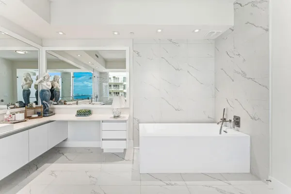 a bathroom with a bathtub a sink and a mirror