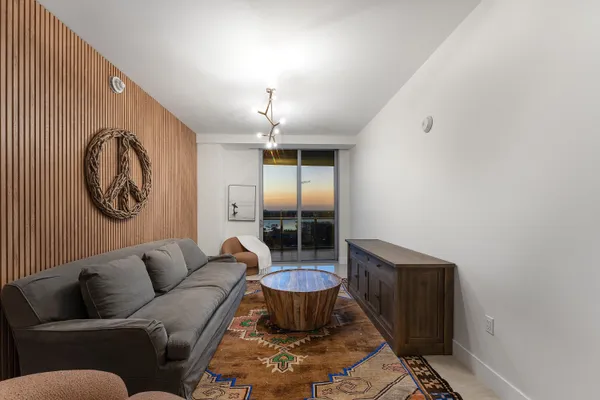 a living room with furniture a window and a lamp