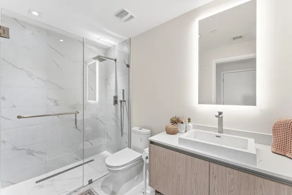 a bathroom with a sink toilet a mirror and shower