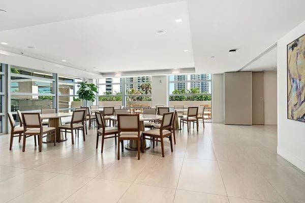 a dining room with furniture a floor to ceiling window and outdoor view