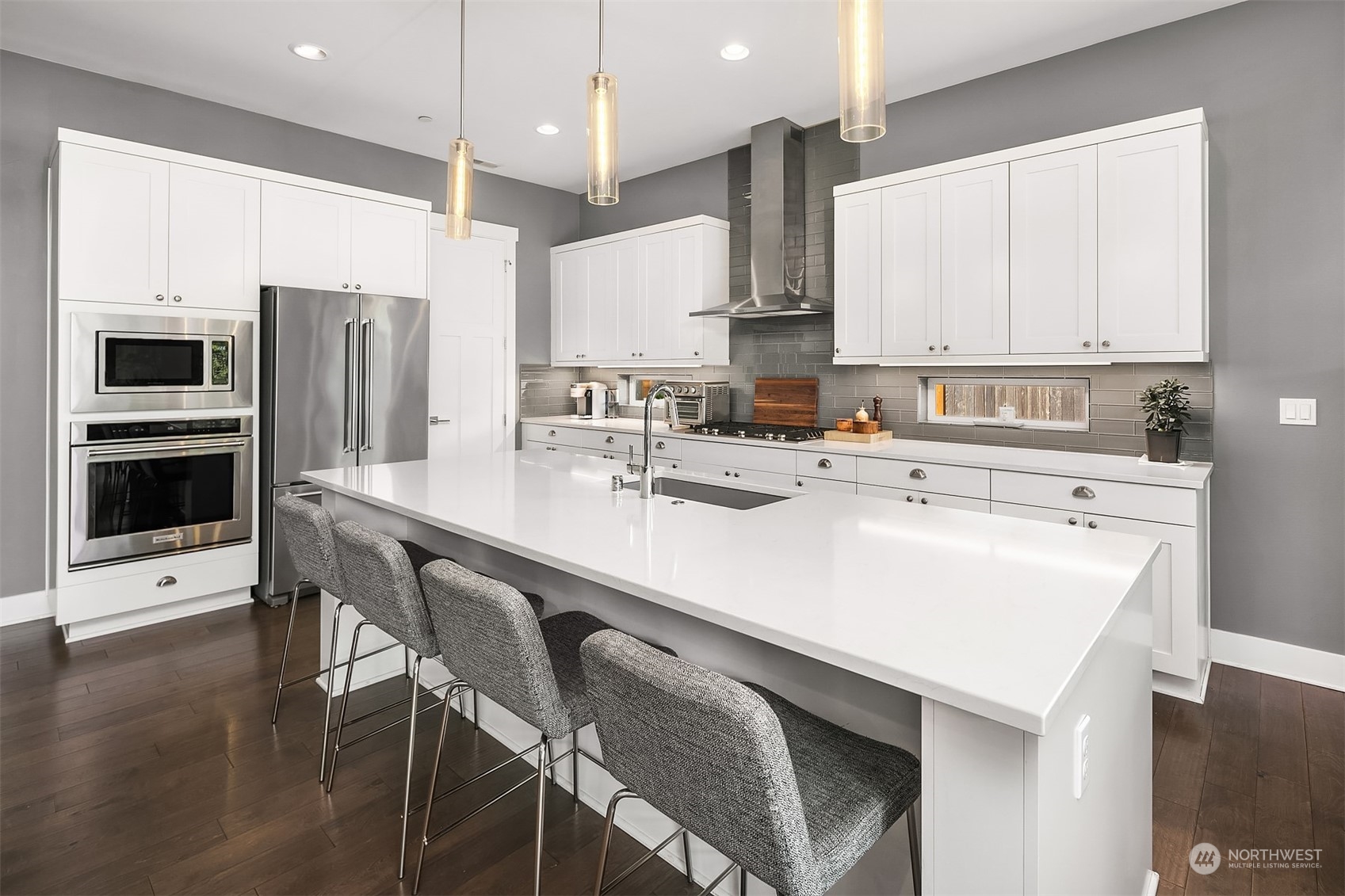 8721 218th Street Southwest Edmonds, WA 98026 - Photo 8 of 34 a kitchen with stainless steel appliances a sink a stove a refrigerator cabinets and a dining table with wooden floor