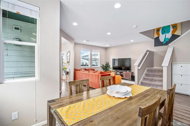 a living room with furniture a large window and wooden floor