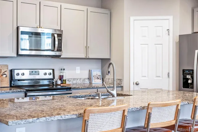 a kitchen with a sink a stove and cabinets