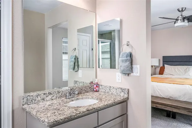 a bathroom with a granite countertop sink mirror and shower