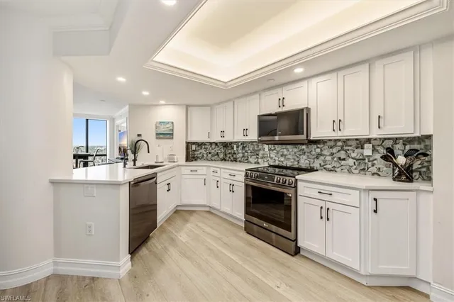 a kitchen with granite countertop white cabinets and white appliances
