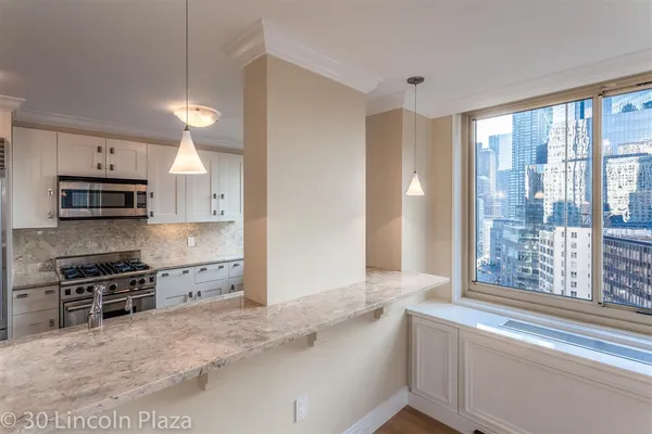 a kitchen with granite countertop a stove a sink and a refrigerator