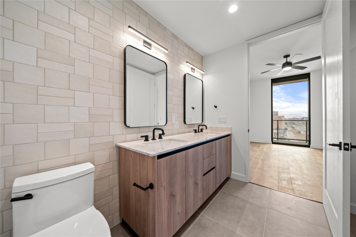 84 East Avenue, Unit 2403 Austin, TX 78701 - Photo 7 of 29 Representative Photo. Primary Bathroom with double vanity, tile patterned floors and backsplash, walk in closet
