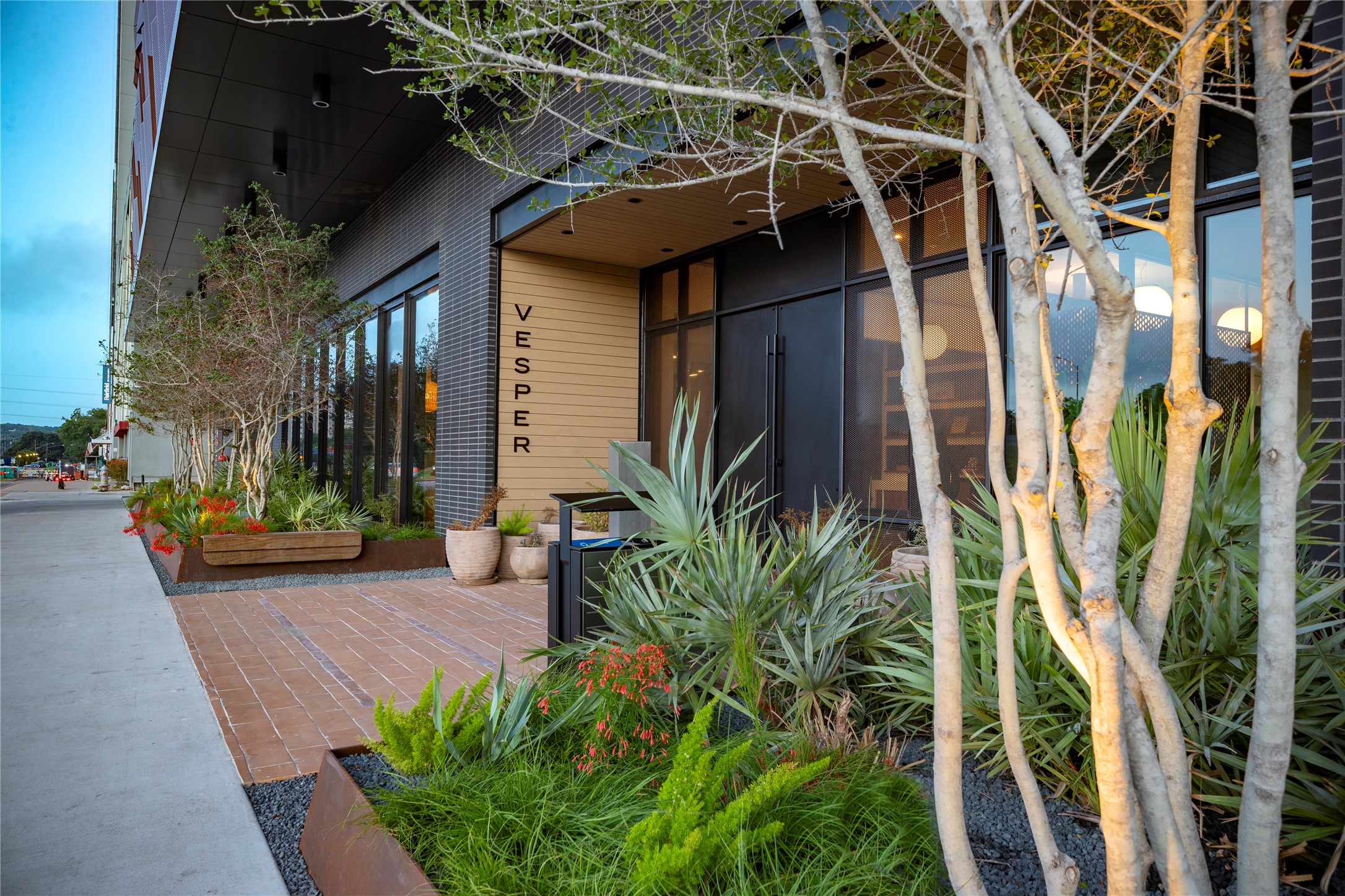 84 East Avenue, Unit 2403 Austin, TX 78701 - Photo 15 of 29 a view of a house with plants and wooden bench