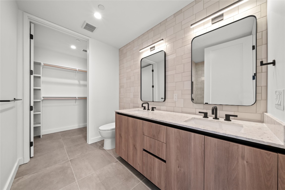 84 East Avenue, Unit 2403 Austin, TX 78701 - Photo 6 of 29 Representative Photo. Primary Bathroom with double vanity, tile patterned floors and backsplash, walk in closet