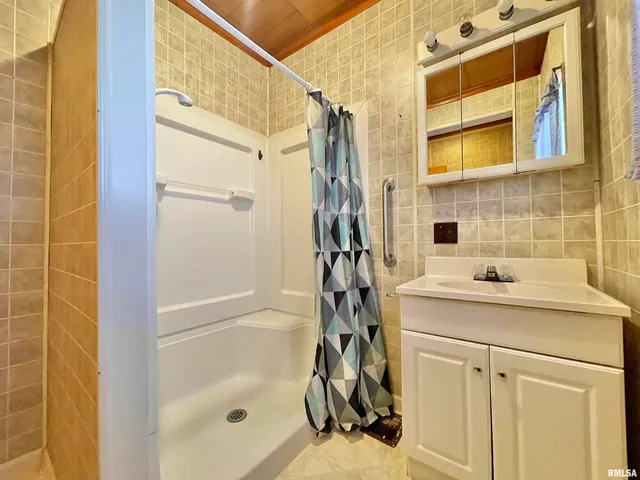 a bathroom with a sink mirror and shower