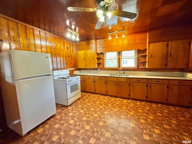 a kitchen with stainless steel appliances granite countertop a refrigerator a sink dishwasher a stove with wooden cabinets