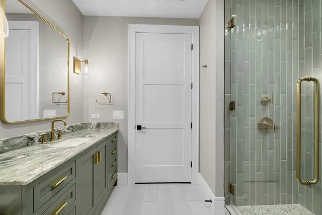 a bathroom with a granite countertop sink shower and a mirror