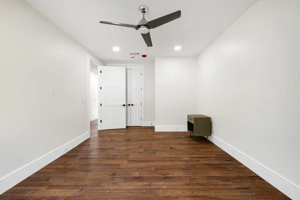 a view of empty room with wooden floor