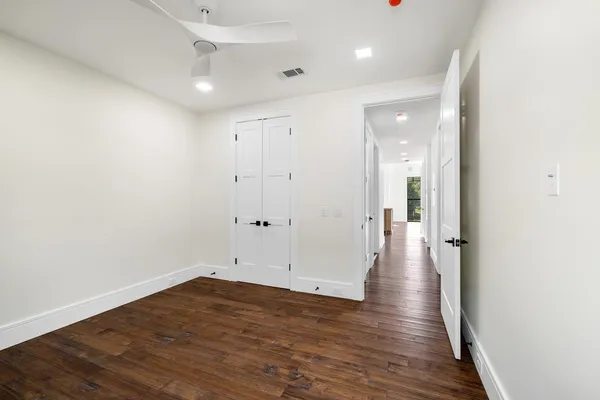a view of a hallway with wooden floor