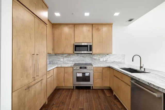 a kitchen with stainless steel appliances granite countertop wooden cabinets a sink and dishwasher