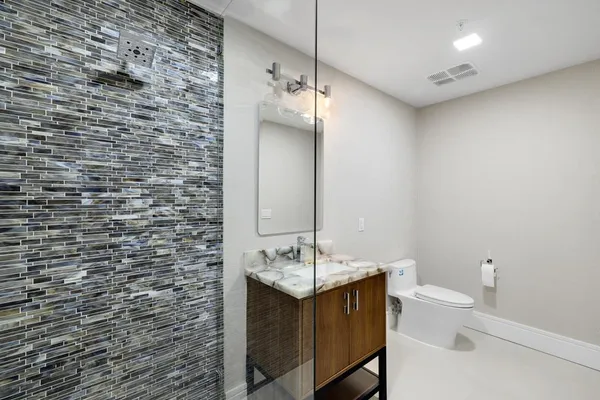 a bathroom with a sink a toilet and mirror