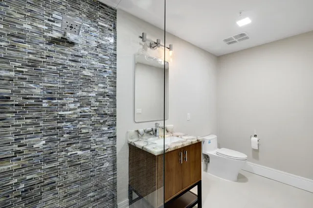 a bathroom with a sink a toilet and mirror