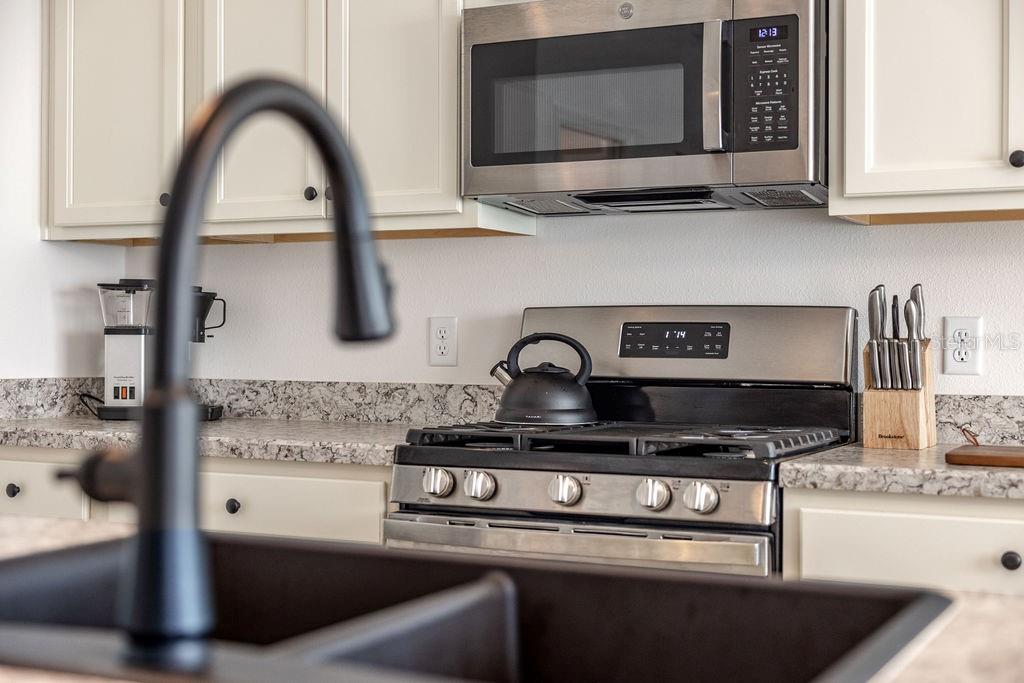 2938 Chimborazo Way The Villages, FL 32163 - Photo 11 of 50 a kitchen with a stove and a microwave