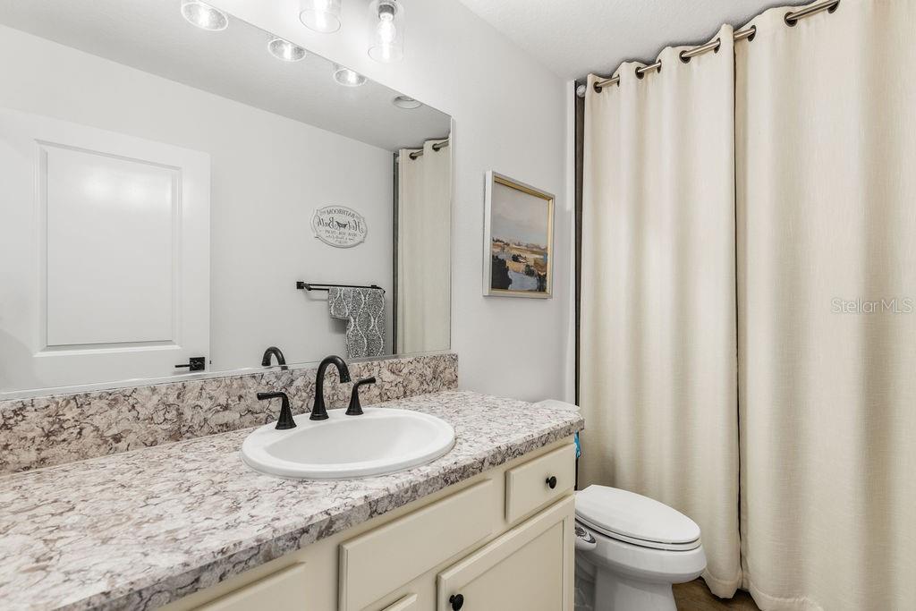 2938 Chimborazo Way The Villages, FL 32163 - Photo 15 of 50 a bathroom with a granite countertop sink toilet and a mirror