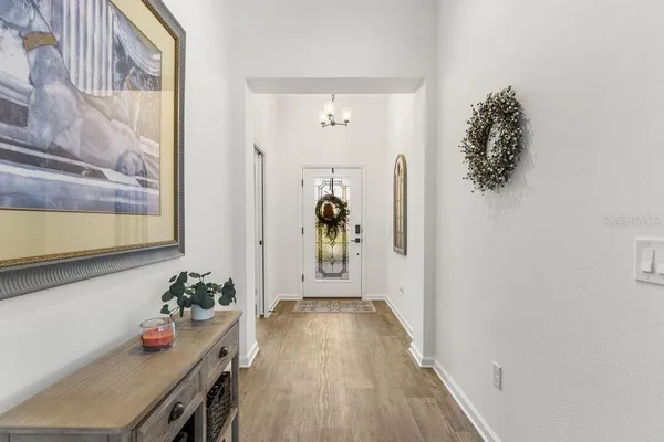 a hallway with front door wooden floor and windows