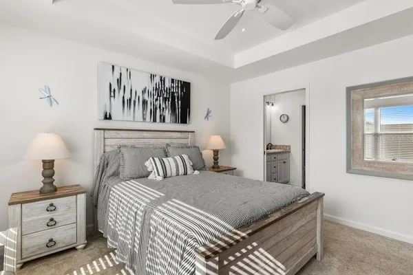a bedroom with a large bed and a chandelier