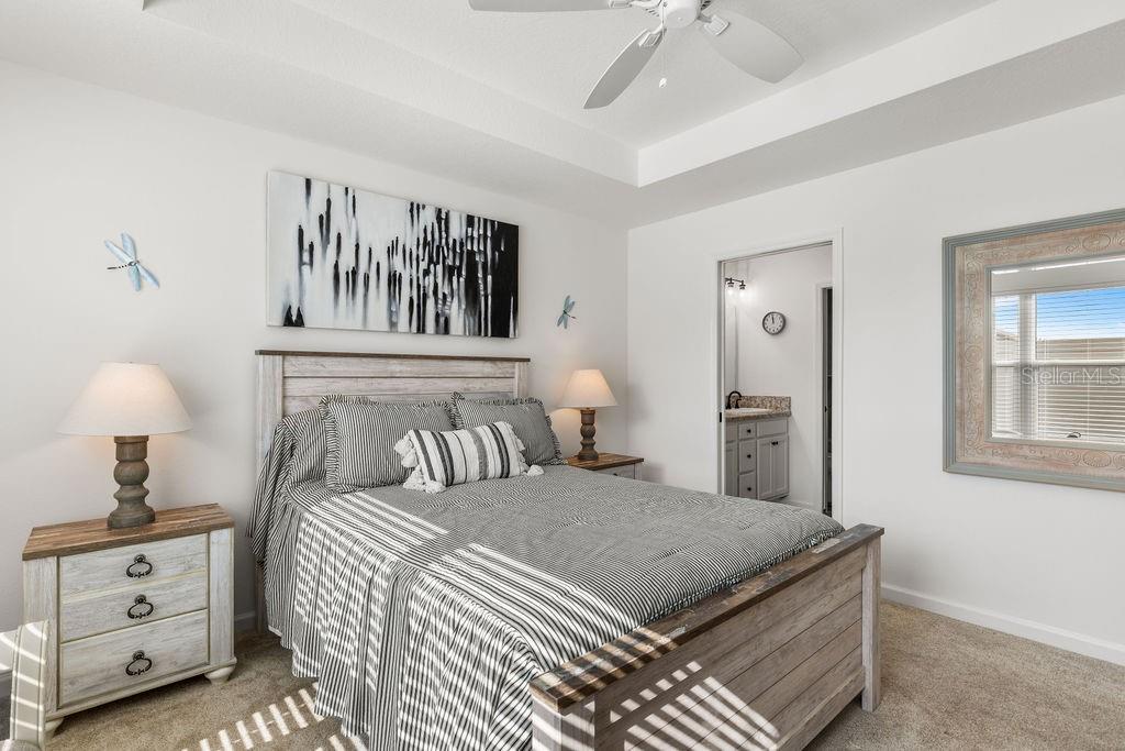 2938 Chimborazo Way The Villages, FL 32163 - Photo 22 of 50 a bedroom with a large bed and a chandelier