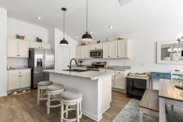 a kitchen with stainless steel appliances kitchen island granite countertop a sink and cabinets