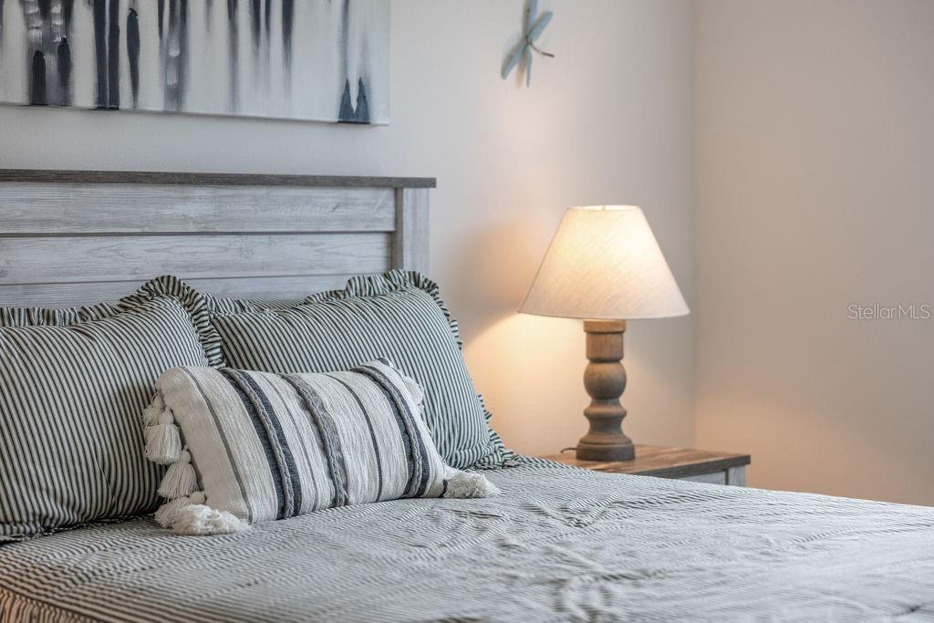 2938 Chimborazo Way The Villages, FL 32163 - Photo 31 of 50 a bedroom with a bed and a lamp