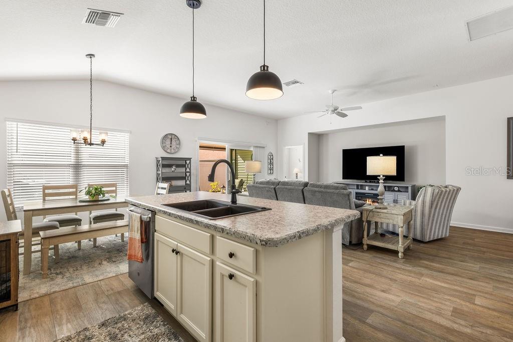 2938 Chimborazo Way The Villages, FL 32163 - Photo 32 of 50 a kitchen with a stove a counter space a sink and a living room view