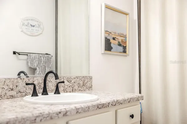 a bathroom with a granite countertop sink and a mirror