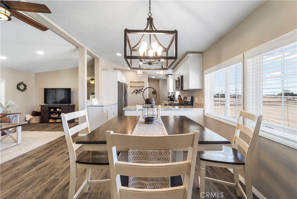 48197 Valley Center Road Newberry Springs, CA 92365 - Photo 15 of 30 a view of a dining room with furniture a chandelier and wooden floor