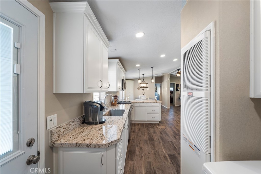 48197 Valley Center Road Newberry Springs, CA 92365 - Photo 18 of 30 a kitchen with white cabinets and wooden floor
