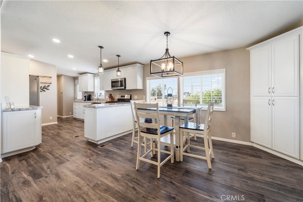 48197 Valley Center Road Newberry Springs, CA 92365 - Photo 2 of 30 a kitchen with stainless steel appliances a dining table chairs stove and refrigerator