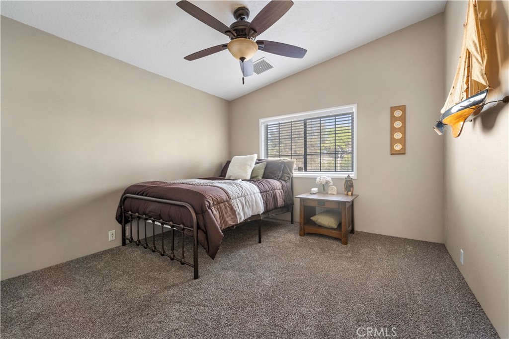 48197 Valley Center Road Newberry Springs, CA 92365 - Photo 23 of 30 a bedroom with a bed and a chandelier